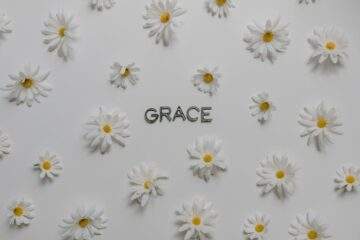 letters surrounded with white flowers on a white surface