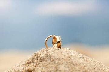 gold wedding bands on sand